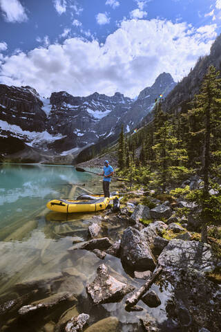 A man prepares for a rafting trip across Cirque Lake in Banff, Alberta stock photo