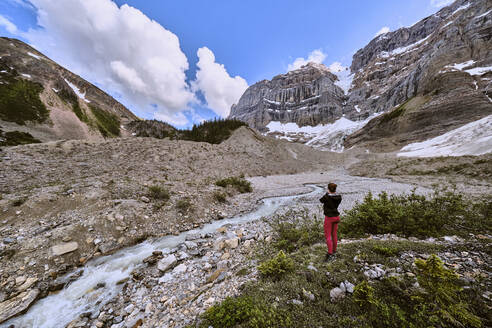 Eine Frau hält an, um ein Foto vom Gletscherabfluss oberhalb des Cirque Lake zu machen. - CAVF72780