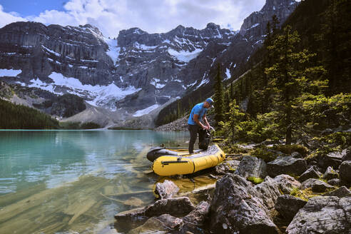 Ein Mann bereitet sich auf eine Rafting-Tour über den Cirque Lake in Banff, Alberta, vor - CAVF72781