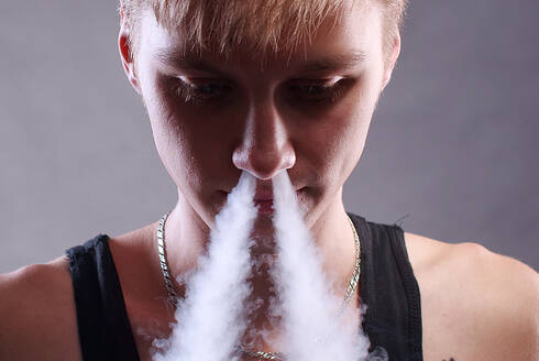 Junger Mann weißer Rauch Nase über grauem Hintergrund - CAVF72802