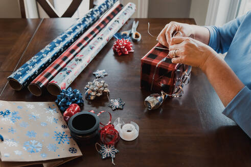 Hände verpacken Geschenk mit Geschenkverpackungsmaterial auf dem Tisch. - CAVF72810