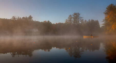 Solo paddling on a misty pond at sunrise. - CAVF72863