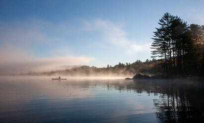 Solo paddling on a misty pond at sunrise. - CAVF72871