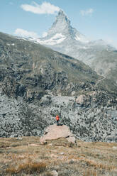 Mittlere Einstellung einer jungen Frau, die vor dem Matterhorn steht - CAVF72891