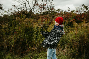 Junges Mädchen lachend und spielend in einem Feld im Oktober in Michigan - CAVF72921