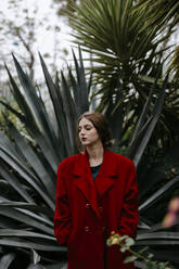 Woman with red coat in a park - TCEF00002