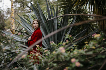 Frau mit rotem Mantel in einem Park - TCEF00003