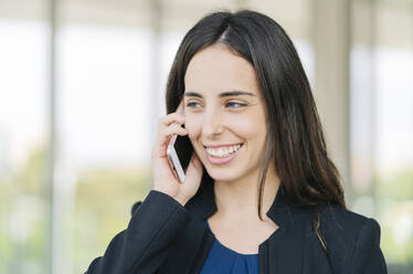 Porträt einer glücklichen Geschäftsfrau beim Telefonieren - DGOF00024