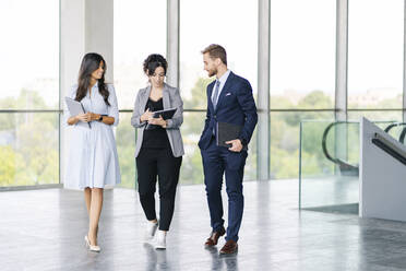 Business team with portable devices on the go - DGOF00033