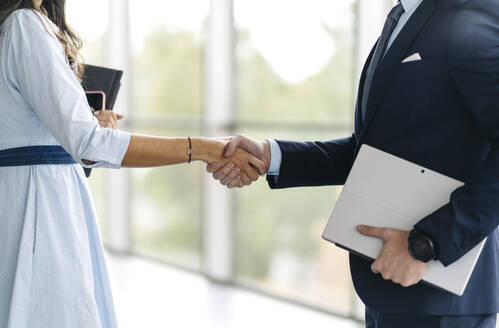 Close-up of businessman and businesswoman shaking hands - DGOF00037