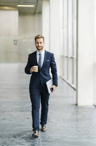 Porträt eines Geschäftsmannes mit Kaffee zum Mitnehmen für unterwegs, lizenzfreies Stockfoto