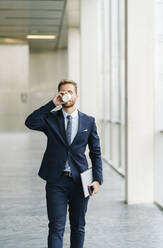 Businessman on the go drinking takeaway coffee - DGOF00053