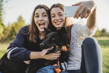 Schwestern machen Selfie mit Hund im Park - CUF54431