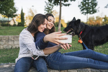 Schwestern machen Selfie mit Hund im Park - CUF54437