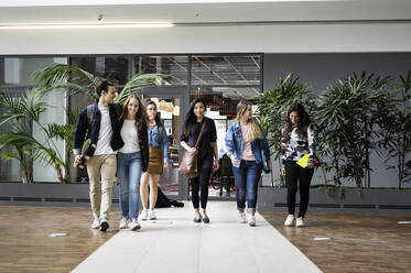 Studenten im Gespräch und beim Gehen auf dem College-Gelände - CUF54475