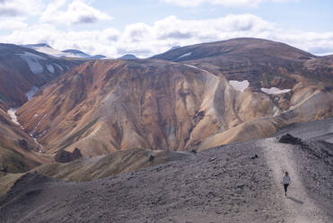 Hiker exploring mountains, Brennisteinsalda and Blᨮjkur, Landmannalaugar, Highlands, Iceland - CUF54528