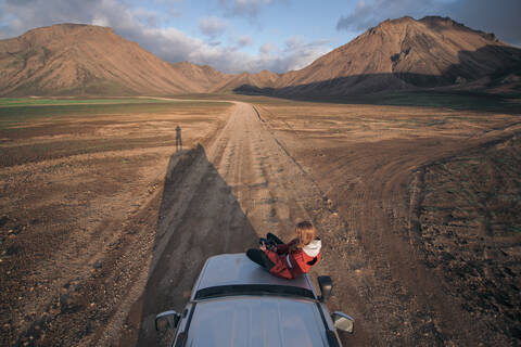 Reisende Frau genießt die Aussicht auf die Landschaft im Fahrzeug, Landmannalaugar, Hochland, Island, lizenzfreies Stockfoto