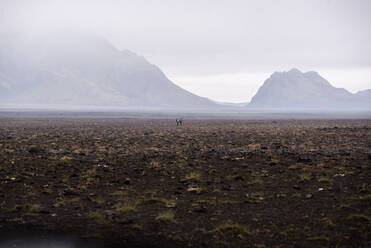 Zwei Menschen inmitten einer weiten, flachen Landschaft, Landmannalaugar, Island - CUF54547