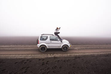 Frau fotografiert vom Dach eines Geländewagens aus, Landmannalaugar, Island - CUF54553