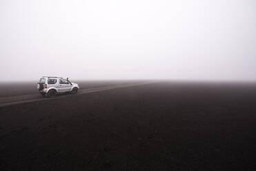 Off road vehicle on dirt track in foggy conditions, Landmannalaugar, Iceland - CUF54554