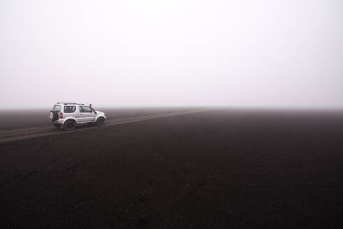 Geländewagen auf unbefestigtem Weg bei nebligem Wetter, Landmannalaugar, Island - CUF54554