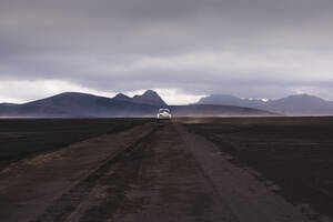 Geländewagen auf unbefestigtem Weg zu den Hügeln, Landmannalaugar, Island - CUF54555