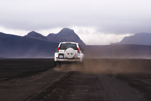 Geländewagen auf unbefestigtem Weg zu den Hügeln, Landmannalaugar, Island - CUF54556