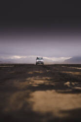 Geländewagen auf unbefestigtem Weg, schwarzer Himmel im Hintergrund, Landmannalaugar, Island - CUF54559