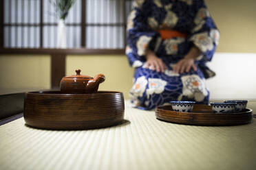 Japan, Teekanne und Teetassen auf einer Tatami-Matte in einem japanischen Ryokan - ABZF02891