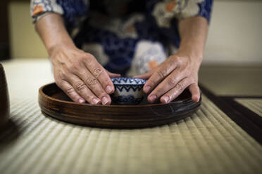 Japan, Hände einer Frau mit Teetasse während einer Teezeremonie - ABZF02892