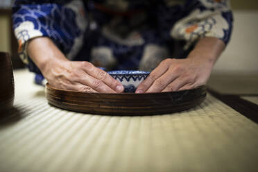 Japan, Hände einer Frau mit Teetasse während einer Teezeremonie - ABZF02894
