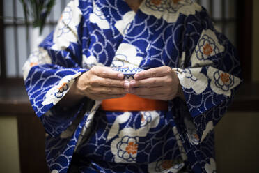 Japan, Mittelteil einer Frau in traditionellem Kimono mit Teetasse - ABZF02899