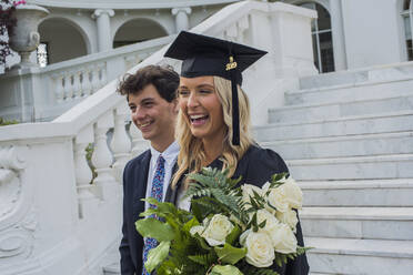 Absolventin mit Blumenstrauß und Bruder auf dem Campus - ISF23731