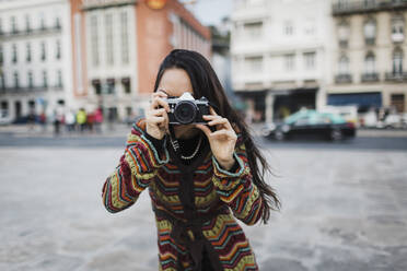 Portrait female tourist using camera on city street - FSIF04514