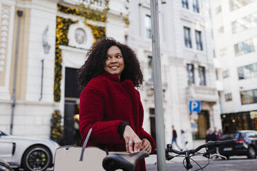 Happy young woman on urban street - FSIF04526