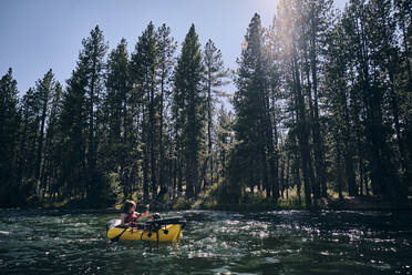 Eine Frau paddelt mit ihrem Schlauchboot den Deschutes River in Zentral-Oregon hinunter - CAVF73045