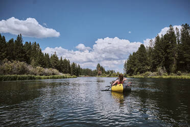 Woman paddles on the Deschutes River in a pack raft in Oregon. - CAVF73054