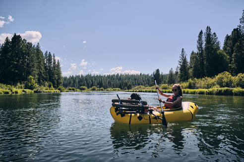 Eine Frau paddelt in einem Packraft auf dem Deschutes River in Oregon. - CAVF73055