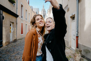 Junge Frauen machen ein Selfie in einer typischen französischen Straße - CAVF73083