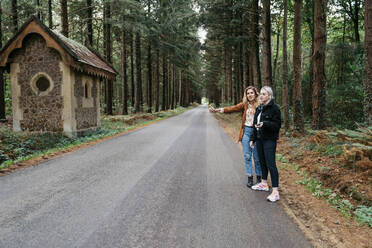 Zwei Frauen, die auf einem Waldweg in Frankreich trampen - CAVF73091