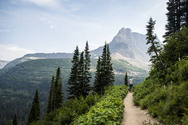 Woman hiking on trail in Rocky Mountains - CAVF73130
