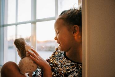 Junges Mädchen spielt zu Hause mit ihrem Spielzeug in Schweden bei Sonnenuntergang - CAVF73346