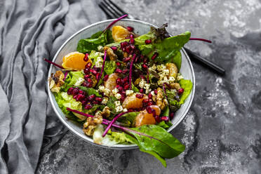 Winter salad with lettuce, tangerines, walnuts, feta and pomegranate seeds - SARF04425