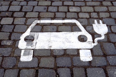 Germany, Baden-Wurttemberg, Electric vehicle charging station symbol on cobblestone - JTF01453