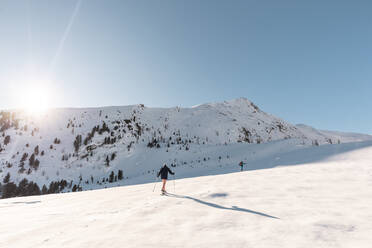 Österreich, Kärnten, Reichenau, Nockberge, Falkert, Mann beim Skitourengehen an einem sonnigen Tag - DAWF01169