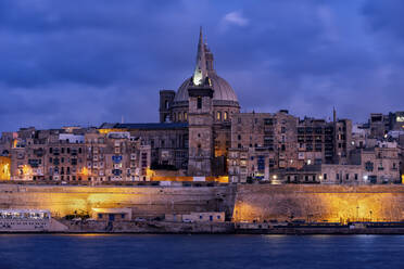 Malta, Valletta, Old town illuminated at night seen across water - ABOF00478