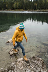 Wanderer auf einem Stein bei den Laghi di Fusine, Friaul-Julisch Venetien, Italien - MAUF03209