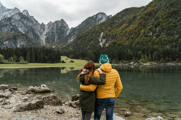 Rear view of couple at Laghi di Fusine, Friuli Venezia Giulia, Italy - MAUF03211