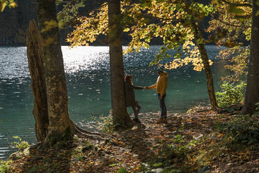 Händchen haltendes Paar an den Laghi di Fusine, Friaul-Julisch-Venetien, Italien - MAUF03226