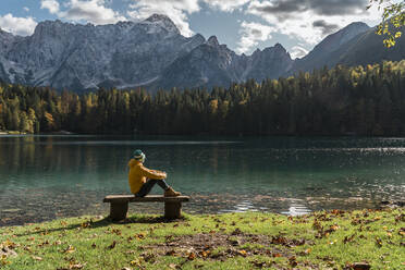 Wanderer sitzt auf einer Bank an den Laghi di Fusine, Friaul-Julisch Venetien, Italien - MAUF03230